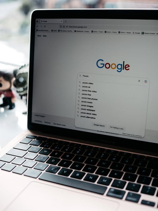 Un primer plano de un portátil que muestra una página de búsqueda de Google con búsquedas relacionadas visibles.